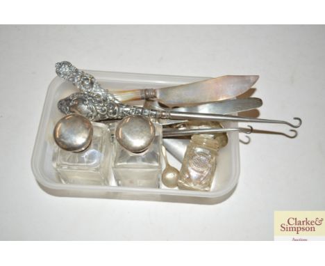 A box containing various silver items to include silver handled button hooks, silver bladed knives, spoons etc.