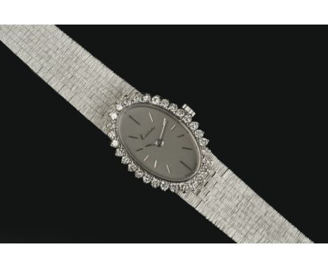 A LADY'S DIAMOND SET BRACELET WATCH BY CHOPARD FOR KUTCHINSKY, the oval silvered dial with baton markers, bordered by round b