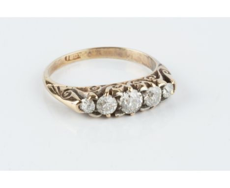 A DIAMOND FIVE STONE RING, the graduated old-cut diamonds to a scroll decorated hoop, stamped '18ct', total diamond weight ap