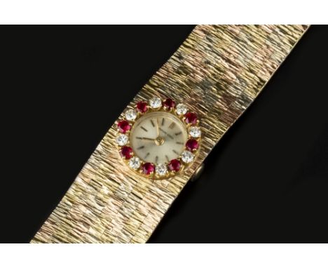 A DIAMOND AND GEM SET BRACELET WATCH BY BUECHE-GIROD, the circular silvered dial with baton markers, to a jewelled manual win