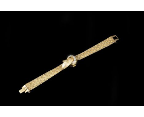A LADY'S DIAMOND SET BRACELET WATCH, the textured ribbon cover highlighted with single-cut diamonds, on a tapered textured br