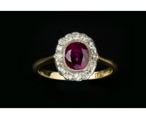 A RUBY AND DIAMOND CLUSTER RING, the oval mixed-cut ruby in millegrain collet setting, bordered by old and single-cut diamond