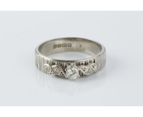 A DIAMOND SET BAND RING, the bark textured band applied with a spray of round brilliant and single-cut diamonds, 18ct white g