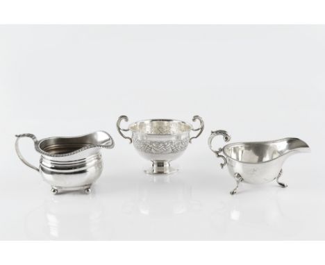 A SILVER MILK JUG, with gadrooned border, on ball feet, by Goldsmiths &amp; Silversmiths Co. Ltd, London 1929, 9cm high, 6 oz