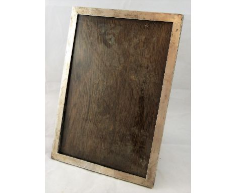 A silver photograph frame, Birmingham 1911, of plain rectangular form with wooden easel back, 30 x 21.5 cm.