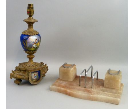 An Art Deco polished stone desk stand, the serpentine oblong base with pen wells and central chrome letter rack flanked by tw