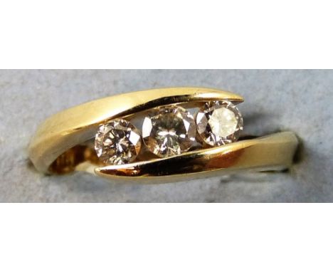 A 10 K three stone diamond ring, channel set with brilliant cut stones, size N.