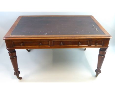 A Victorian mahogany library table, of oblong form with inset top and two long and one short frieze drawers, two with fitted 