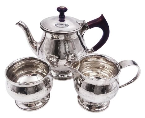 Silver Arts and Crafts style three piece bachelors tea service, comprising teapot, cream jug and sugar bowl, each of baluster