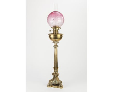 VERITAS LAMP WORKS BRASS LARGE TABLE OIL LAMP, of fluted column form with acid etched later cranberry shade and ornate tri-fo