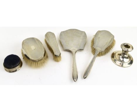 A George V hallmarked silver four-piece dressing table set. The lot to include a hand mirror, a brush and two clothes brushes