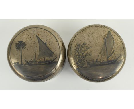 A pair of 20th century Iraqi silver niello tea caddies. Each tea caddy being decorated with an etched scene of boats and figu