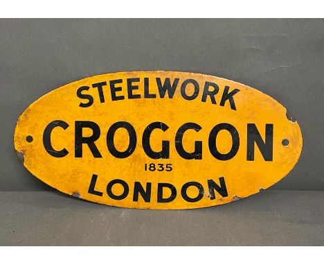 An oval enamel yellow sign, advertising a plumbing company