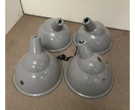 Four iconic circa 1950 vitreous glass enamel parabolic light shades by Benjamin. The shades are in good condition, with some 