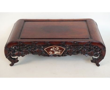 CHINESE CARVED HARDWOOD STAND
with a pierced frieze decorated with vines and mother of pearl inlay, standing on scroll end su