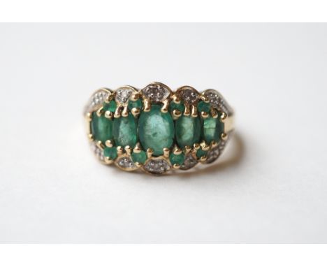 EMERALD AND DIAMOND CLUSTER DRESS RING
the central oval and round cut emeralds in diamond surround, on nine carat gold shank,