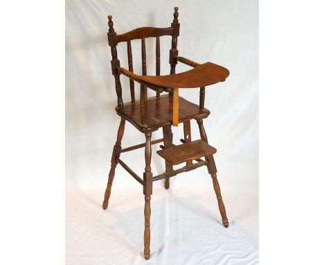 CHILD'S ELM AND OAK HIGH CHAIR
with a shaped spindle back, shelf and adjustable footrest, standing on shaped turned supports 