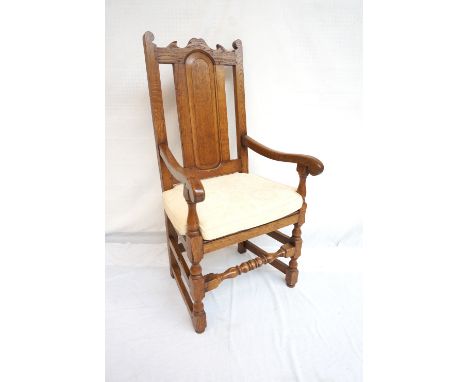 18th CENTURY STYLE OAK AND ELM ARMCHAIR
with a shaped panelled back, the arms terminating in scrolls with turned supports abo