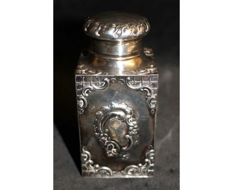 A Victorian silver rococo revival caddy and cover repousse with foliate scrolling cartouches and with similar borders, by SWS