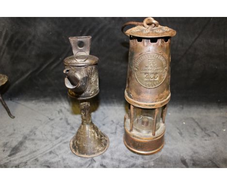 An Eccles protector lamp and lighting co miners lamp, early 20th century and a 19th century tinplate standing lamp on spreadi