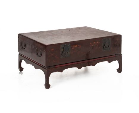 A CHINESE LACQUERED TRUNK ON STAND
With twin handles to each end, the top decorated with a court scene, the side with previou