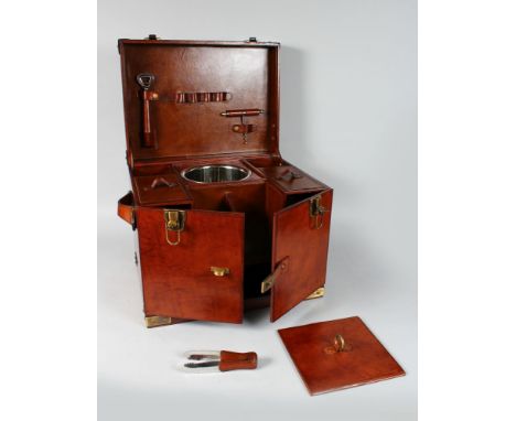 A GOOD LARGE LEATHER CHAMPAGNE HAMPER with rising top, champagne bucket, double doors to the front. 17.5ins long, 14ins high.