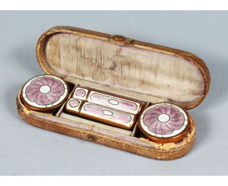 A LEATHER CASE containing two enamel top bottles and two lipsticks. 6ins long.