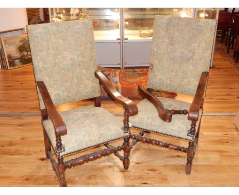 A pair of 17th century style open armchairs, covered in foliate fabric, on square and bobbin turned legs joined by an H-shape