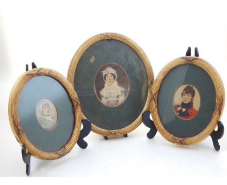 An early 19th century oval portrait miniature of an English officer in red frock coat together with two oval minitures of lad