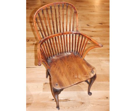 An early 19th century Thames Valley area yew and elm Windsor comb back elbow chair, with saddle seat on cabriole legs, with c