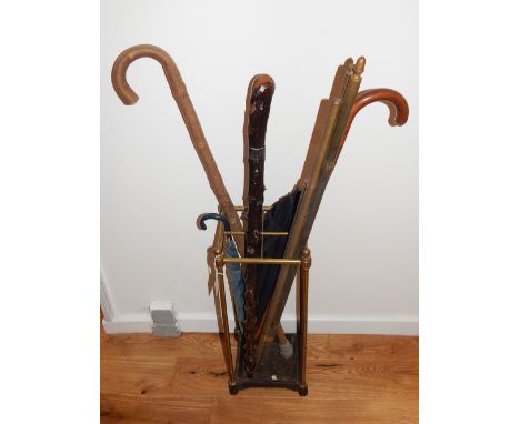 An early 20th century tubular brass four-division stick stand, together with a white metal mounted black thorn cane, a bamboo