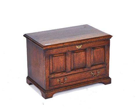 AN 18TH CENTURY STYLE OAK COFFER BACHWith lift top over triple panel front and faux drawer, 67cm wide; 40.5cm deep; 46cm high