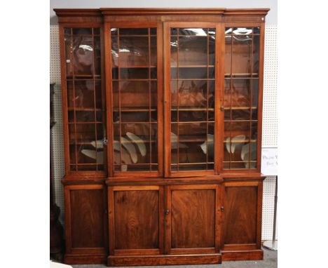 A GEORGE III MAHOGANY BREAKFRONT BOOKCASE CABINETWith four astragal glazed doors over four panel cupboards, on plinth base, 2