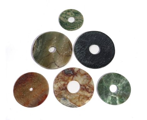 SIX CHINESE ARCHAISTIC JADE BI DISCSOf various size and colour One carved with taotie masks, 8cm to 12.5cm diameter (6)Overal