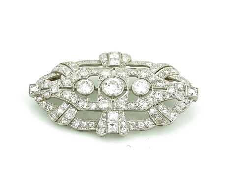 A DIAMOND BROOCHCirca 1920, in a pierced openwork panel shaped geometric design, collet set with the three principal cushion 