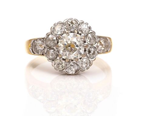 AN 18CT GOLD AND DIAMOND CLUSTER RINGClaw set with the principal cushion shaped diamond at the centre, in a surround of ten s