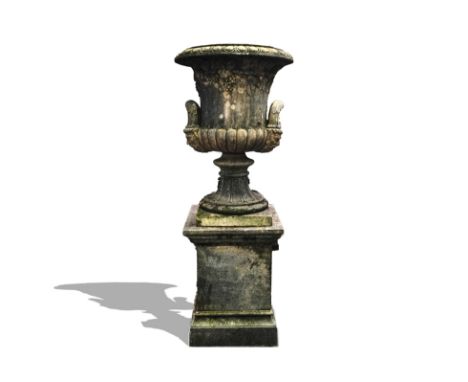 A LARGE RECONSTITUTED STONE URNWith vine and grape moulded body over twin Bacchus handles on fluted soccle and stepped square