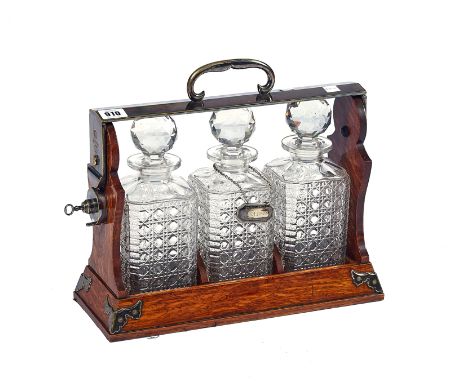 BETJEMANN’S PATENT; A LATE 19TH CENTURY SILVER PLATE AND OAK THREE BOTTLE TANTALUSMarked on handle ‘ BETJEMANN’S PATENT 23044