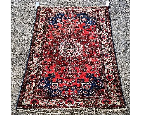 A BAKHTIARI RUG, PERSIANThe madder field with a dark madder faceted medallion, floral indigo spandrels; an ivory border190cm 