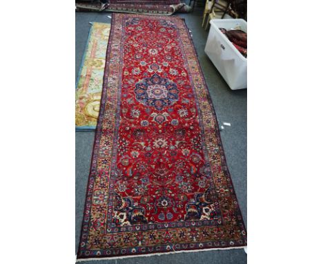 A TABRIZ CARPET, PERSIANThe madder field with a bold indigo medallion, matching spandrels, all with a bold palmette and flora