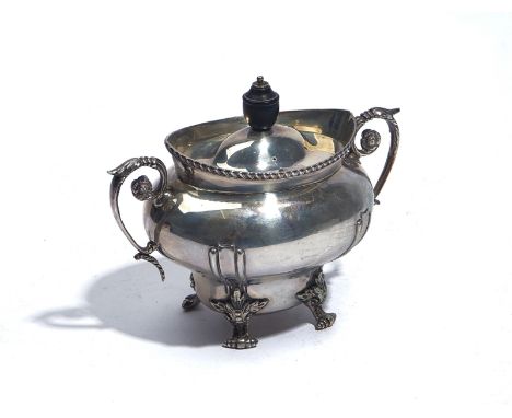 A SILVER TEA CADDYOf oval form, decorated with a gadrooned rim, the scrolled handles with floral motifs, raised on four folia