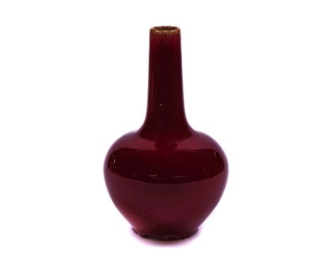 A CHINESE FLAMBÉ-GLAZED VASEOf bottle form, covered in a deep red glaze, 19cm highSome chipping around the foot