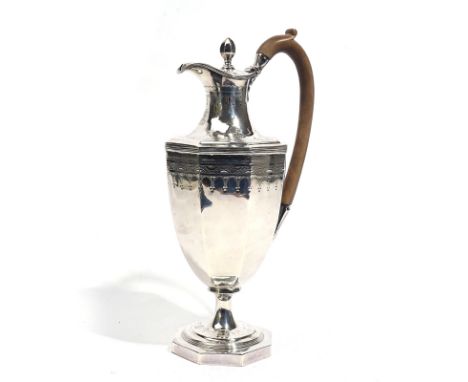 A GEORGE III SILVER HOT-WATER JUGOf octagonal vase shaped form, with engraved decoration, raised on an octagonal foot, with a