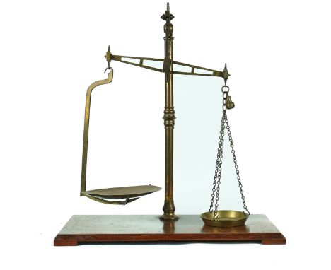A SET OF BRASS WEIGHING SCALESBy Wedderburn, Southampton, Early 20th CenturyMounted on a mahogany base, 67cm highCondition re