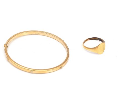 A GOLD BANGLE AND A 9CT GOLD SIGNET RING (2)The gold oval hinged bangle on a snap clasp, detailed 9 KT, the 9ct gold oval sig