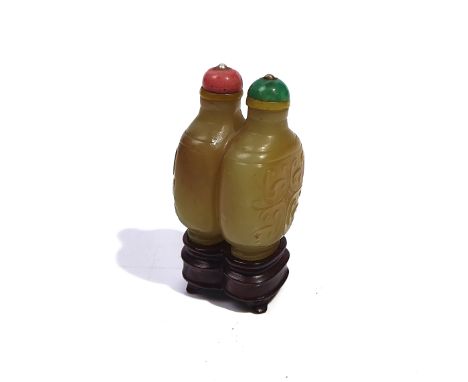 A CHINESE JADE DOUBLE SNUFF BOTTLEFormed as two conjoined rounded rectangular bottles carved with scrolls, the stone of yello