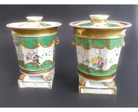 A pair of 19th Coalport pot pouri: circular pierced lids with fluted chimney; circular tapering bodies decorated with lion ma