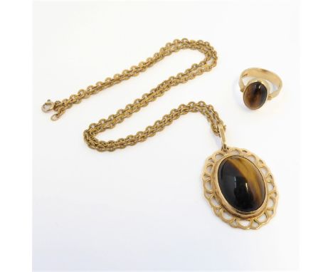 An oval tiger's eye cabochon pendant and ring: the pendant within a collet and openwork border, the ring to a plain tapering 