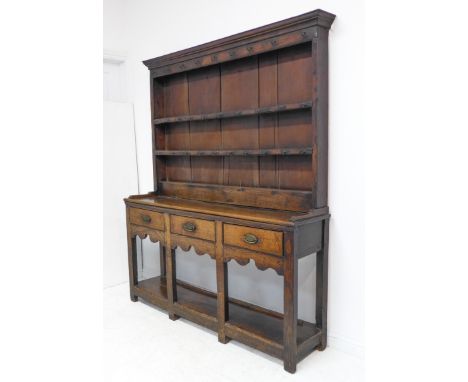 An 18th century oak dresser of good colour and pleasing small proportions: the shelved superstructure above a base section wi