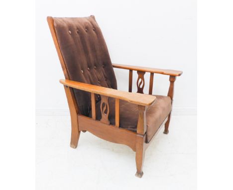 A stylish Arts and Crafts style oak reclining armchair: shaped arms above vertical splats (the central splat pierced) with bu
